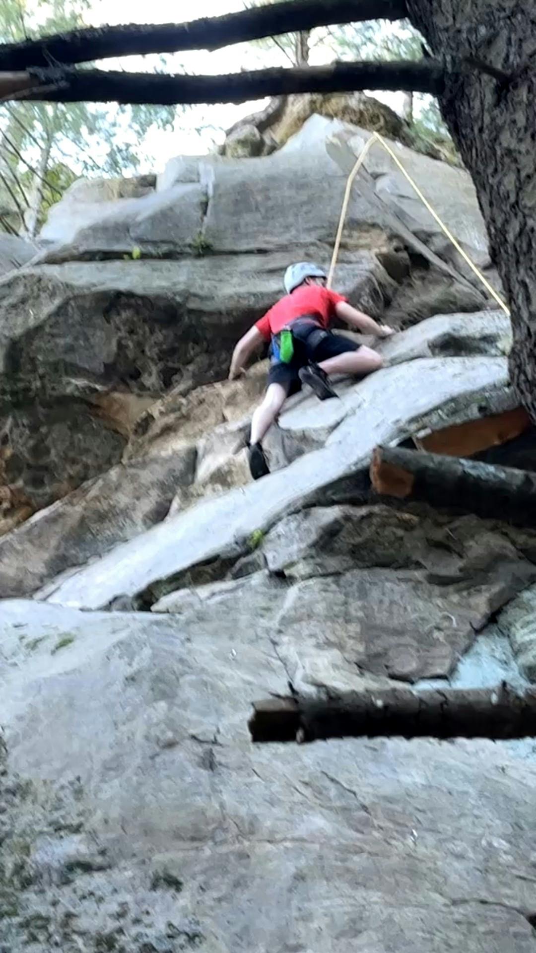 Image of Jordan Ready outside scaling a rock face with rock climbing saftey equipment